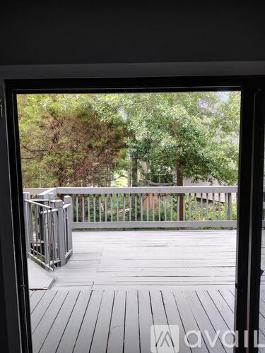 A balcony with a railing and a view of trees.