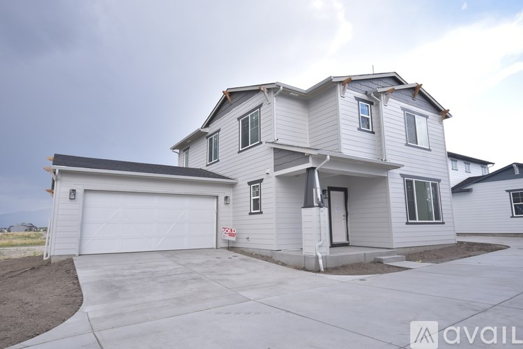 A two-story house with a garage is available for sale.