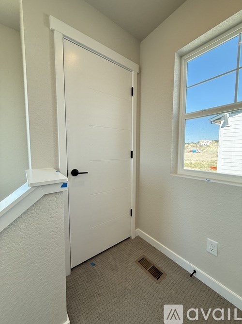 A bathroom with a toilet, sink, and window.