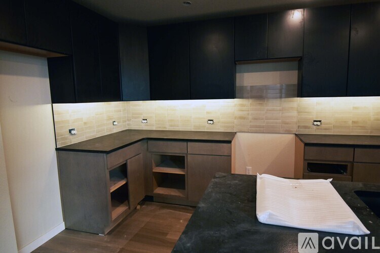 A kitchen with black cabinets and a countertop with a white paper towel on it.