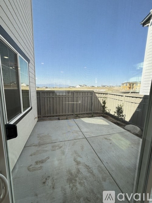 A room with a ceiling fan and a black box on the floor.