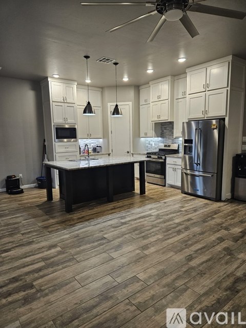 A kitchen with a refrigerator, stove, and cabinets.