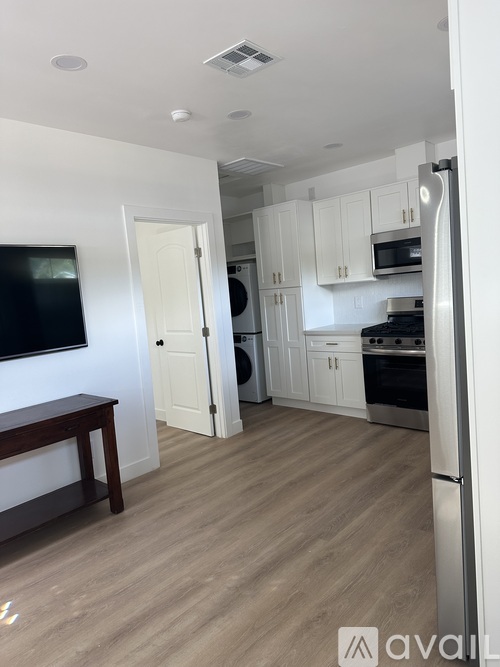 A kitchen with white cabinets and a wooden floor.