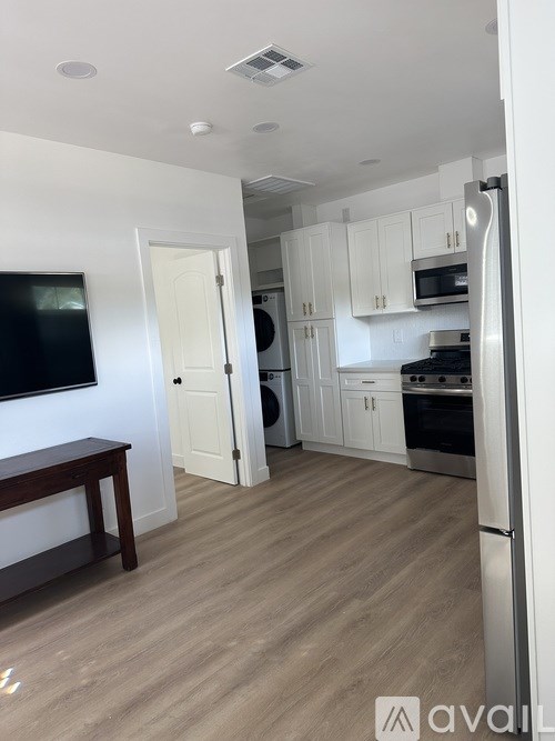 A kitchen with white cabinets and a wooden floor.