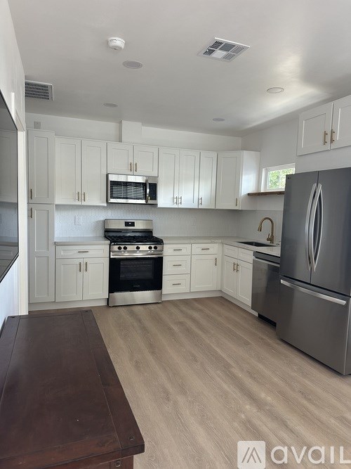 A kitchen with white cabinets and a wooden table.