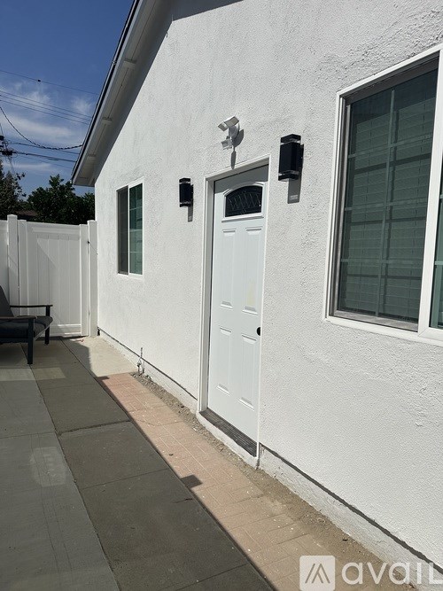 A white house with a grey door and a window.