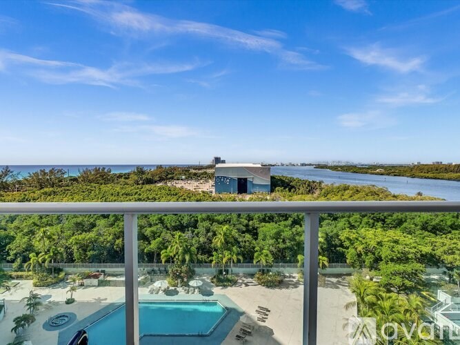 A house with a pool and a balcony overlooking the ocean.