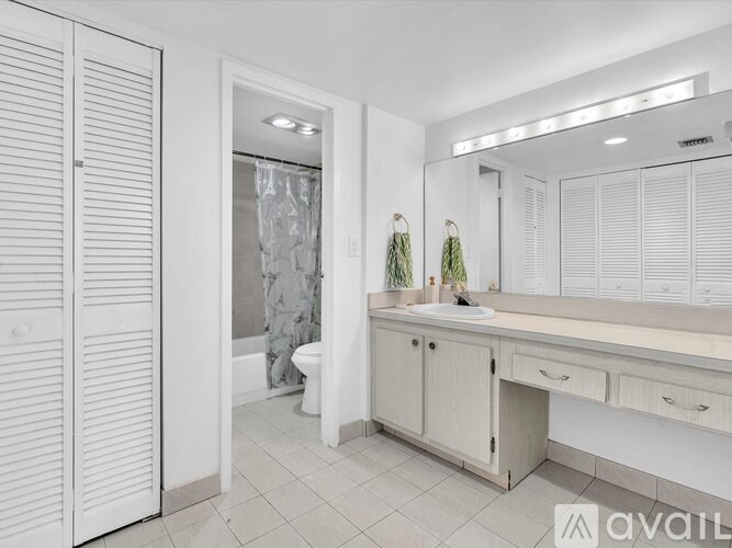 A bathroom with a white vanity and a white toilet.