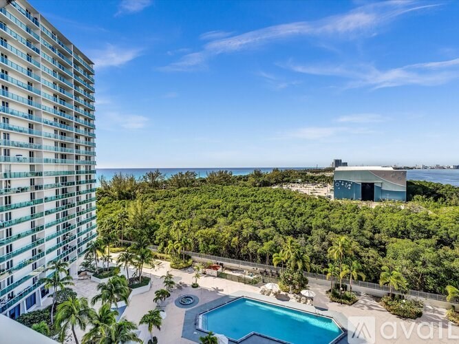 A tall building with a pool in front of it.