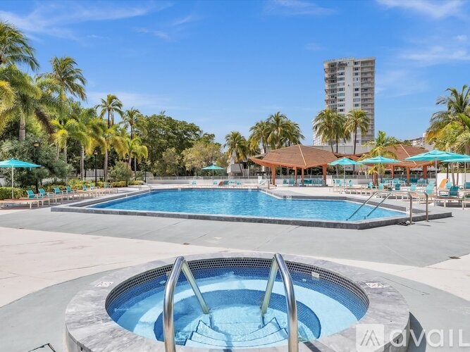 A large outdoor swimming pool surrounded by palm trees and lounge chairs.