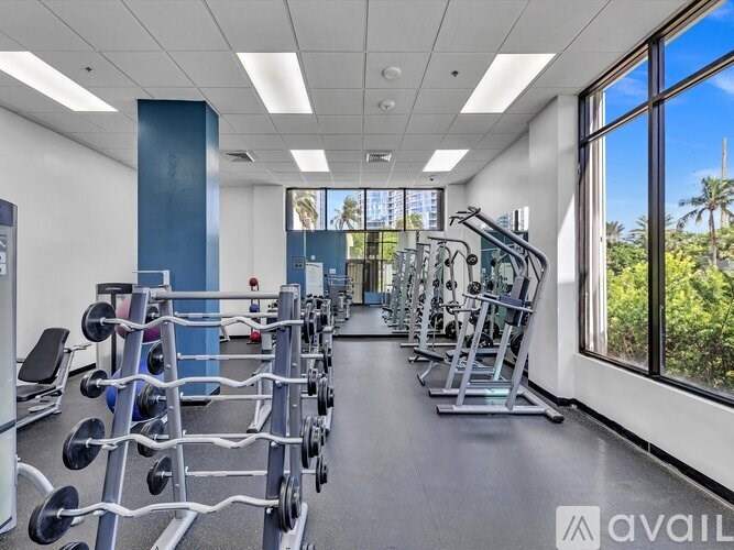 A gym with a variety of equipment including weight machines and free weights.