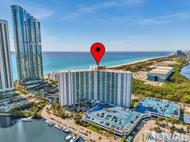 A red location marker is placed on a building in a coastal city.
