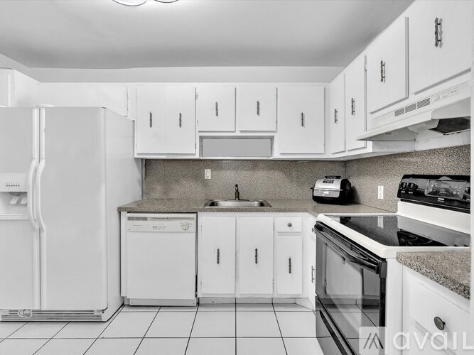 A kitchen with white appliances and cabinets.