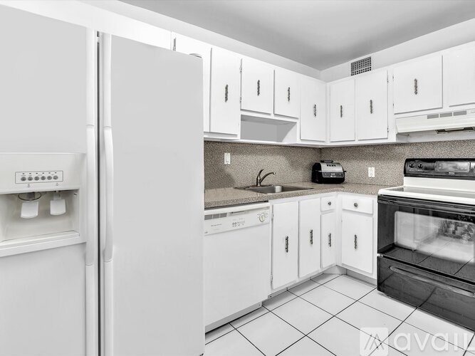 A kitchen with white appliances and cabinets.