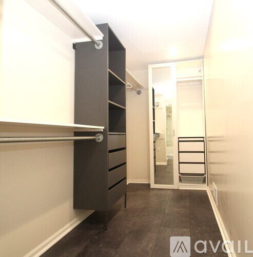 A hallway with a black and white wardrobe and a glass door.