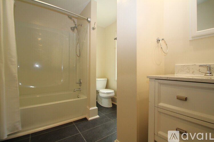 A bathroom with a toilet, sink, and shower.