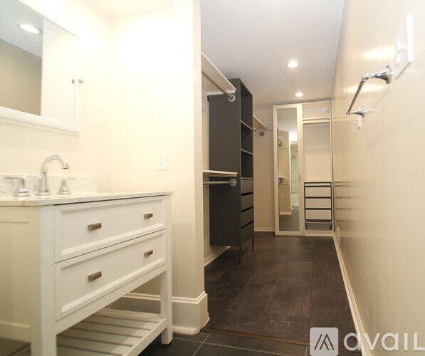 A bathroom with a white vanity and a walk-in shower.