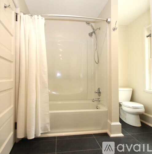 A white bathroom with a glass shower stall and a toilet.