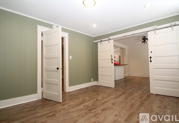 A room with white doors and wooden floors.