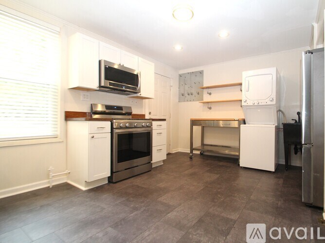 A kitchen with white appliances and wooden shelves.