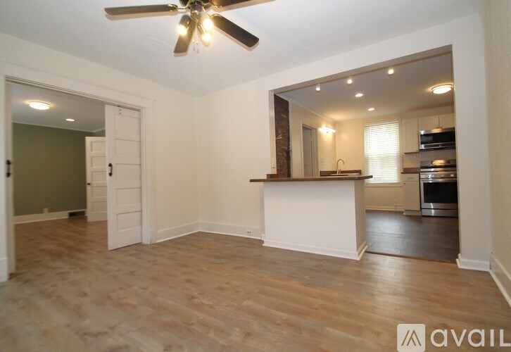 A room with a ceiling fan and wooden flooring.