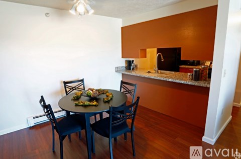 A kitchen with a table and chairs.