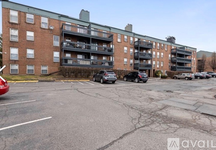 A parking lot in front of a brick apartment building.