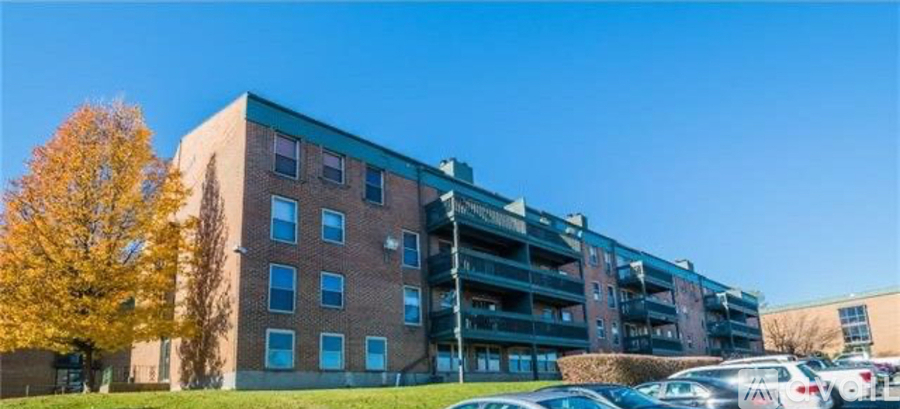A large apartment building with a parking lot in front.