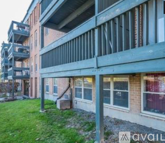 A building with a balcony and a window with a view of a lawn.