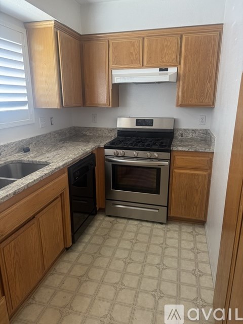 A kitchen with wooden cabinets and a granite countertop.