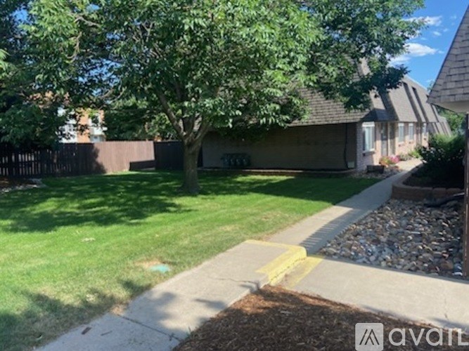 A tree in a yard with a house in the background.