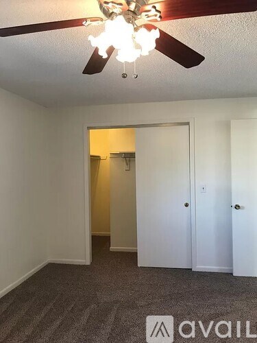 A room with a ceiling fan and a carpeted floor.