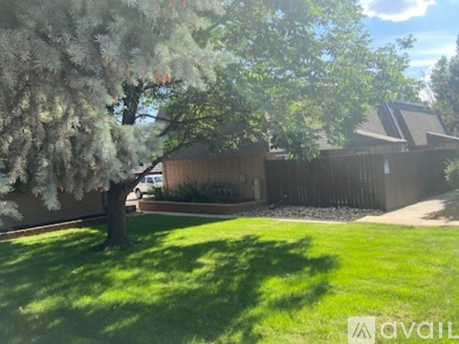 A tree with white flowers is in front of a house.