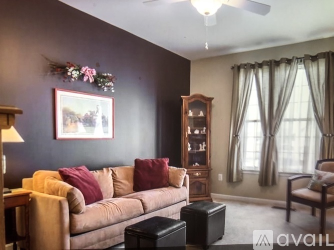 A living room with a couch, chair, and a painting on the wall.