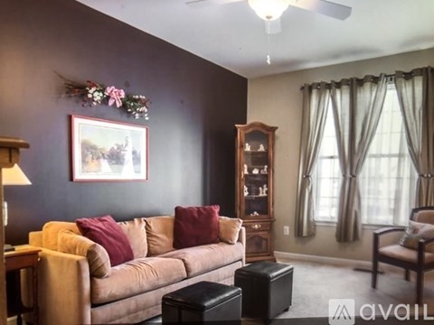 A living room with a couch, chair, and a painting on the wall.