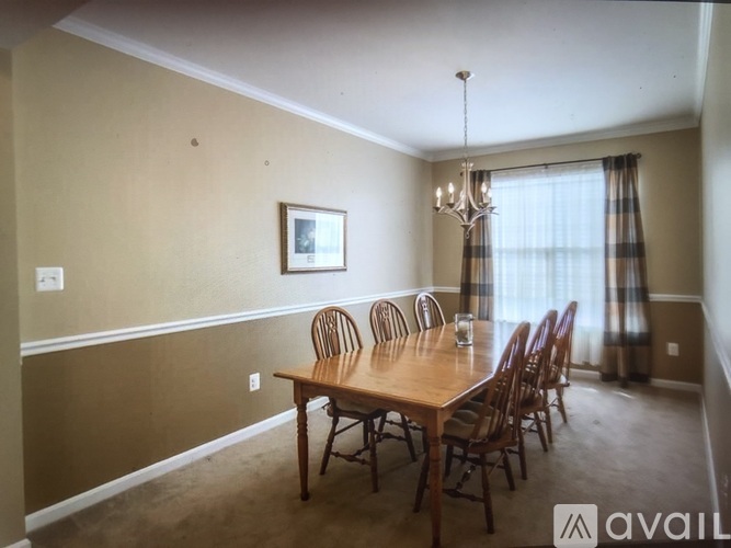 A dining room with a wooden table and chairs.