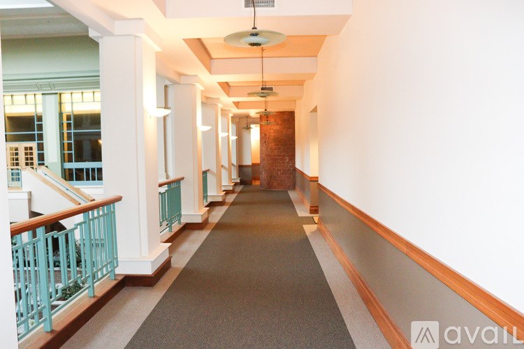 A long hallway with a carpeted floor, white walls, and a wooden ceiling.