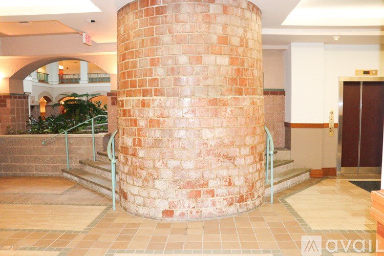 A large brick pillar in a building with a plant to the left.