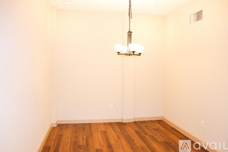 A room with wooden floors and a chandelier hanging from the ceiling.