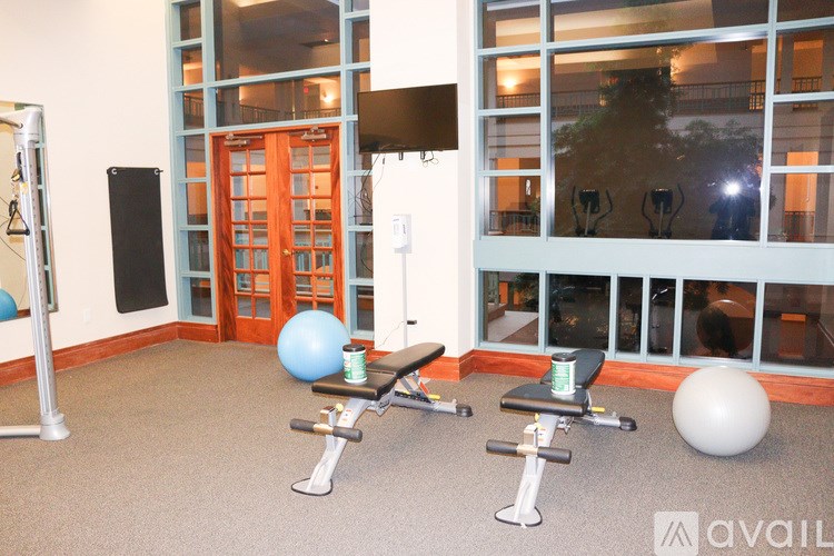 A gym with a variety of equipment including weights and a medicine ball.