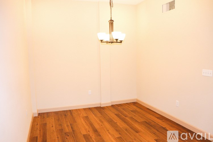A room with wooden floors and a chandelier hanging from the ceiling.