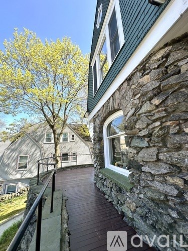 A house with a green roof and a stone wall.