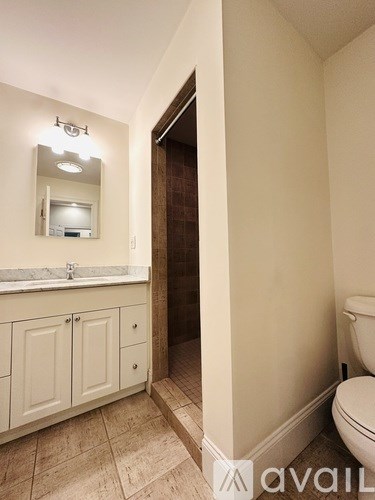 A room with a ceiling fan and a desk with a computer.