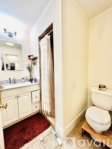 A small bathroom with a toilet, sink, and mirror.