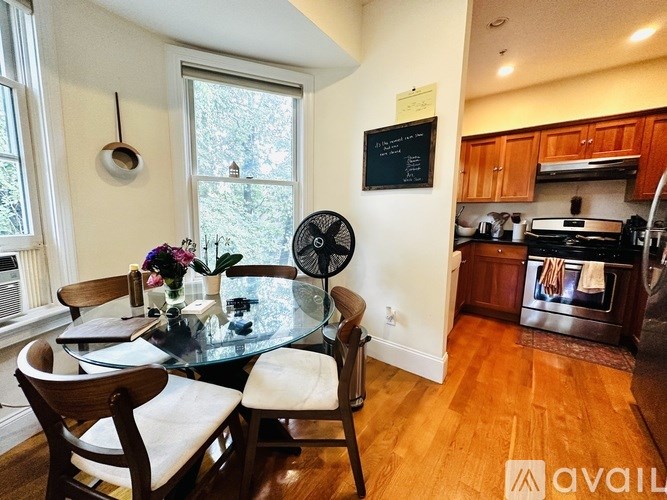 A kitchen with a table and chairs in front of a window.