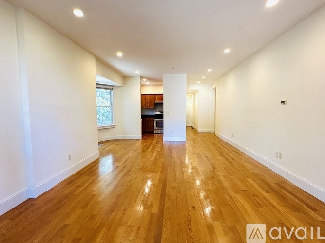 A kitchen with wooden cabinets and a stainless steel refrigerator.