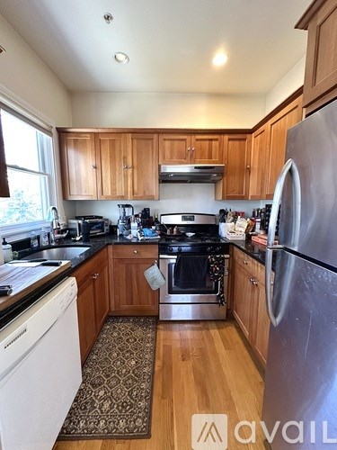 A kitchen with wooden cabinets and a stainless steel refrigerator.