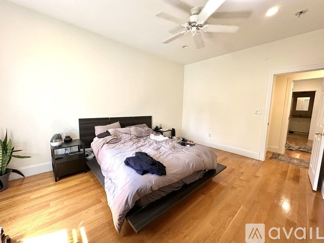A bedroom with a large bed and a ceiling fan.