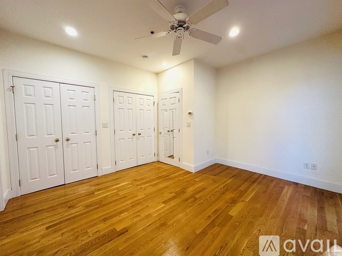 A room with a desk, chair, and a fan.