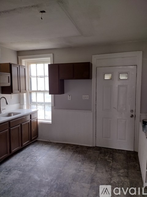 A kitchen with brown cabinets and a white door.